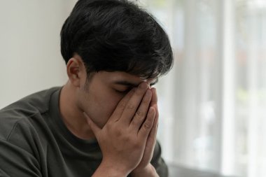 Depresyon ve akıl hastalığı. Asyalı adam kötü haber aldıktan sonra üzülür. Stresli çocuk mutsuz problemle kafasını karıştırıyor, kız arkadaşla tartışıyor, ağlıyor ve beklenmedik işler için endişeleniyor, ekonomide düşüş var..