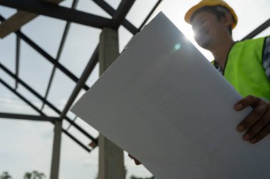 Müfettiş ya da mühendis mavi baskı kullanarak inşaat ve kalite güvencesini denetliyor. Mühendis, mimar ya da irtibat kurucu ev sahibine teslim etmeden önce evi inşa etmek için çalışır.