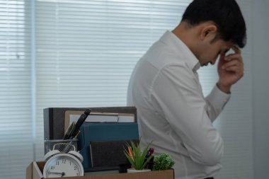Stresli iş adamları şirketten istifa edecek. İçinde kişisel eşyalar olan kahverengi bir karton kutuyu kaldırıyor. İstifa, iş yerleştirme ve boşluklar kavramı.