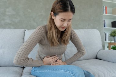 stomach ache. Asian women have abdominal pain, indigestion, gastritis, menstrual cramps, flatulence, diarrhea, distention, colon cancer, belly inflammation problem, suffer food poisoning, abdomen