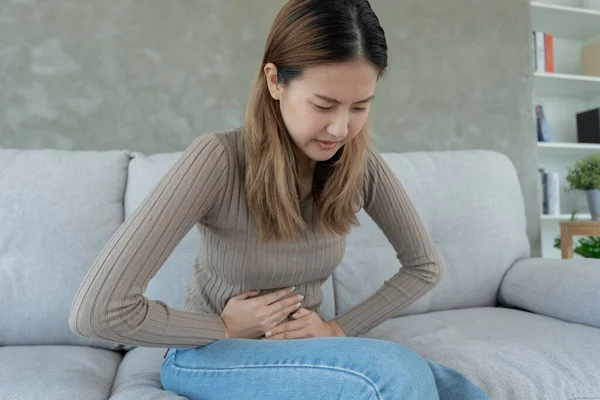 stock image stomach ache. Asian women have abdominal pain, indigestion, gastritis, menstrual cramps, flatulence, diarrhea, distention, colon cancer, belly inflammation problem, suffer food poisoning, abdomen