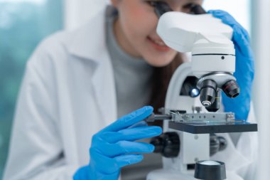 Bilimadamı ileri bilimsel laboratuvarda biyokimyasal örnekleri analiz ediyor. Tıbbi profesyonel kullanım mikroskobu virüsün mikrobiyolojik gelişimini gösteriyor. Fen laboratuvarında biyoteknoloji araştırması.