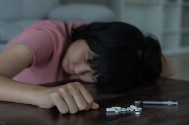 Asyalı kadın aşırı dozda hap kullanıyor, stresli, üzgün, uyuşturucu bağımlısı, hasta, sağlıksız, mutsuz, intihar, depresyon veya ümitsiz, uyuşturucu bağımlısı, yaşam ve aile sorunları, motivasyonsuz