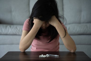 Asyalı kadın aşırı dozda hap kullanıyor, stresli, üzgün, uyuşturucu bağımlısı, hasta, sağlıksız, mutsuz, intihar, depresyon veya ümitsiz, uyuşturucu bağımlısı, yaşam ve aile sorunları, motivasyonsuz