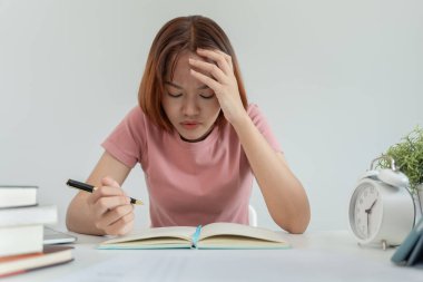 Asian student woman have anxiety because of exams, female prepare for test and learning lessons in the library. stress, despair, haste, misunderstanding reading, discouraged, expectation, knowledge