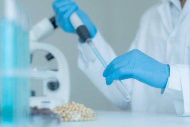 Bilimadamı laboratuvardaki tüm kimyasal tanecikleri kontrol ediyor. Kontrol uzmanları kimyasal kalıntıların konsantrasyonunu inceliyor. Tehlike, standart, yasaklı maddeler, kirlilik, mikrobiyolog