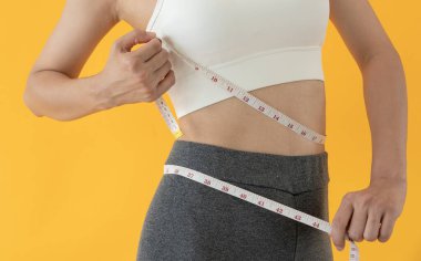 Diyet ve diyet. Güzel, ince kadın vücut ölçüsü. Spor elbiseli bir kadın sağlıklı yaşam için kilo verme hedefine, zayıflığa, ince belliye, beslenme uzmanına ulaşır..