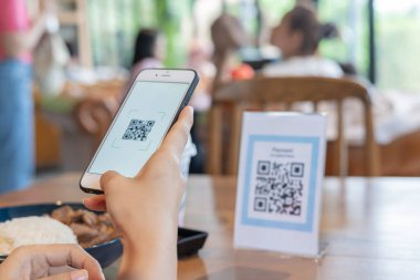 Kadın, kafeterya restoranında sipariş menüsü için dijital dağıtım ile QR kodunu taramak için akıllı telefon kullanıyor. Menüyü ve siparişi seçin ve indirimi toplayın. E cüzdan, teknoloji, online ödeme, kredi kartı, banka uygulaması.
