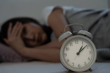 Asyalı kadın geç saatlere kadar uyumaya çalışıyor uykusuzluk çekiyor, uykusuzluk çekiyor ya da bir kabusta korkuyor üzgün endişeli ve stresli görünüyor. Yorgun ve baş ağrısı ya da gecenin bir yarısı uyanan migren..