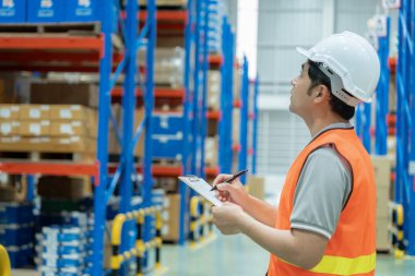 Depo çalışanı, envanterde ve stok ürünlerinde kutu ürünlerini kontrol ediyor. Lojistik ticaret nakliyat ve teslimat müşterilere, denetim, depo, depo, fabrika