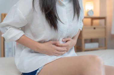 stomach ache. Asian women have abdominal pain, indigestion, gastritis, menstrual cramps, flatulence, diarrhea, distention, colon cancer, belly inflammation problem, suffer food poisoning, abdomen