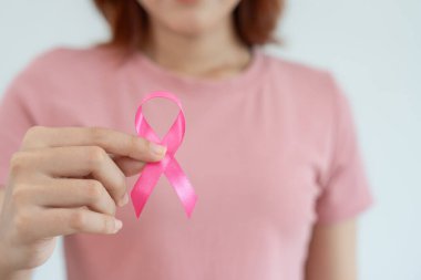 Woman hold pink ribbon breast cancer awareness. Female health check consciousness. international Women Day and World Cancer Day. sign cancer, Symbolic, health care, support patients, timely diagnosis