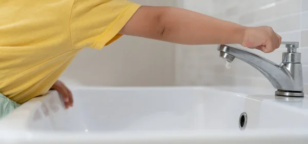 Säästä Vettä Pikkupoika Sammuttaa Jatkuvasti Juoksevaa Vettä Kylpyhuoneessa Suojellakseen Ympäristöä — kuvapankkivalokuva