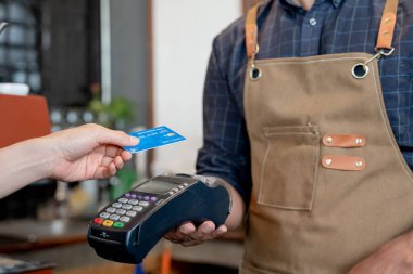 Kadın, kafeteryada nakit olmadan dijital ödeme yaparak kredi kartı ödemesini internet üzerinden yapıyor. İndirim biriktir. E cüzdan, teknoloji, online ödeme, kredi kartı, banka uygulaması. günlük yaşam ödemesi