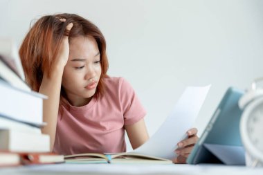 Asian student woman have anxiety because of exams, female prepare for test and learning lessons in the library. stress, despair, haste, misunderstanding reading, discouraged, expectation, knowledge