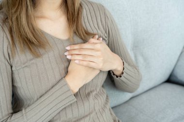 Göğüs kafesinde kalp krizi belirtileri var. Asyalı kadınlarda göğüs ağrısı var. Kalp rahatsızlığı, sızıntı, genişleme, genişlemiş kalp, göğse acı verici bir ifadeyle bastırma.