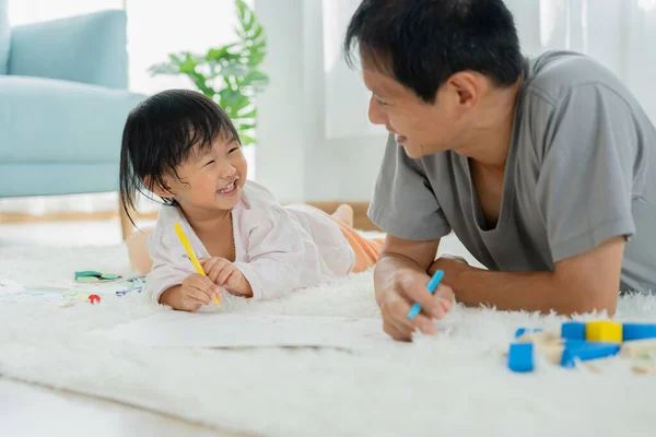Happy Asia father playing learning paint for little child. Funny family is happy and excited in the house. Mother and daughter  having fun spending time together. Holiday, Activity
