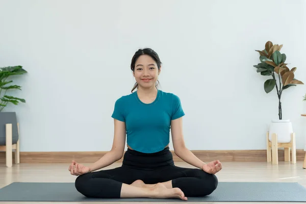 Slim woman practicing yoga on room of her condo or home. Asian woman doing exercises in morning. balance, meditation, relaxation, calm, good health, happy, relax, healthy lifestyle, diet, slim