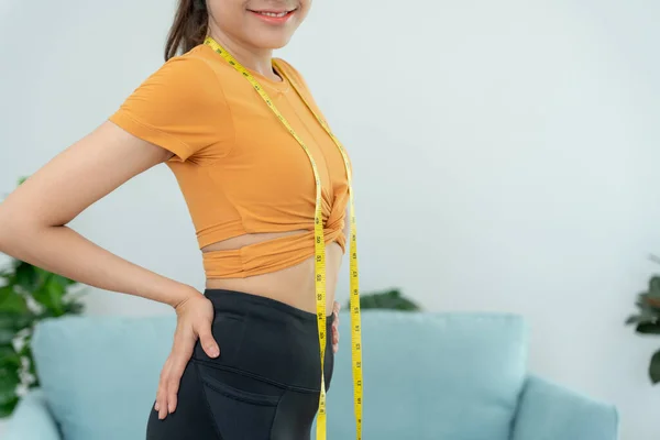 asian women happy results of diet. Beautiful shape. female have a reduced waist size after under going a weight loss corse. can not wear jean due to weight loss. balance, control, routines, exercise.