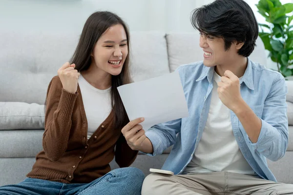 asian couple with happy and feel good finish and close large bills or invoices. close money to pay to expenses and credit card debt. shortage, mange financial problems, mortgage, refinancier, owner.