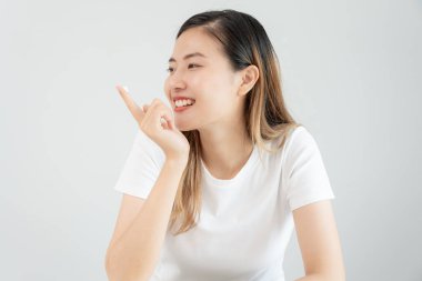 Güzel Asyalı kadın gülümsüyor, cilt kremi kullanıyor. Sağlıklı bir kadın yüzüne krem sürün ve makyaj yapın. Cilt kremi reklamı, kırışıklık önleyici, bebek yüzü, beyazlatma, nemlendirici, gözenekleri sıkılaştırma serumu.