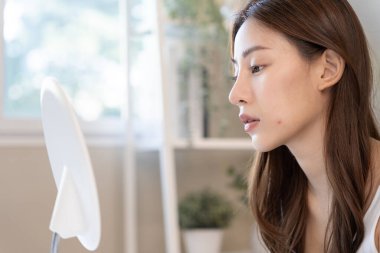Genç Asyalı kadın, yüz dermatolojisi ve kozmetik ürünlerinde steroidlere alerjisi olduğu için endişeli. Hassas cilt, güneş yanığı, sivilce, kimyasallara alerjisi, yüzünde kızarıklık. cilt sorunları ve güzellik