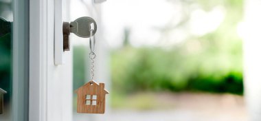 Landlord key for unlocking house is plugged into the door. Second hand house for rent and sale. keychain is blowing in the wind. mortgage for new home, buy, sell, renovate, investment, owner, estate clipart