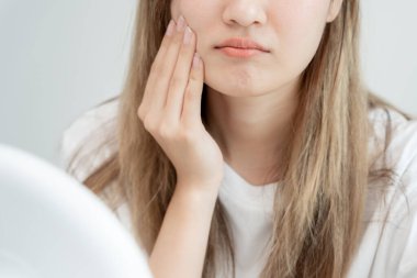 Genç Asyalı kadın, yüz dermatolojisi ve kozmetik ürünlerinde steroidlere alerjisi olduğu için endişeli. Hassas cilt, güneş yanığı, sivilce, kimyasallara alerjisi, yüzünde kızarıklık. cilt sorunları ve güzellik