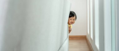 Küçük Asyalı çocuk kanepenin arkasında saklambaç oynuyor sevimli çocuk evde eğleniyor. Mutlu aile çocuklarla eğlenir, etkinlik, öğrenme, aktivite, oyun, meditasyon