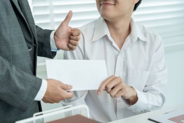 Businessmen receive salary or bonuses from management or Boss. Company give rewards to encourage work. Smiling businessman enjoying a reward at the desk in the office.