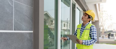 inspector or engineer is inspecting construction and quality assurance new house using a checklist. Engineers or architects or contactor work to build the house before handing it over to the homeowner