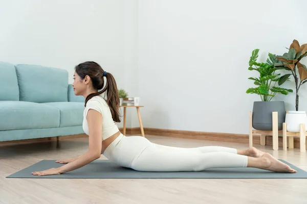 Slim woman practicing yoga on room of her condo or home. Asian woman doing exercises in morning. balance, meditation, relaxation, calm, good health, happy, relax, healthy lifestyle, diet, sli