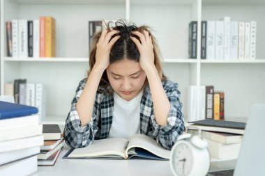 Asian student woman have anxiety because of exams, female prepare for test and learning lessons in the library. stress, despair, haste, misunderstanding reading, discouraged, expectation, knowledge