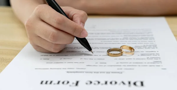 Divorce. Woman remove married ring and sign Divorce form. Couples desperate and disappointed after marriage. wife sad, upset and frustrated after quarrels conflict. distrust, love problems