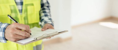 inspector or engineer is inspecting construction and quality assurance new house using a checklist. Engineers or architects or contactor work to build the house before handing it over to the homeowner