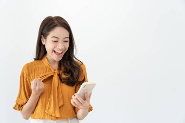 Asian beautiful woman exited surprise face expression . female feels shocked with the phone. exciting smile and happy adorable rejoices. Very enjoy and fun relax time. wow, girl holding smartphone
