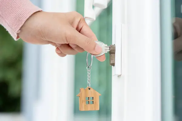 Landlord key for unlocking house is plugged into the door. Second hand house for rent and sale. Owner use hand unlock door mortgage for new home, buy, sell, renovate, investment, owner, estate