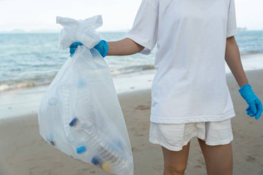Okyanusu kurtar. Gönüllü olarak plajdaki çöpleri topluyor ve plastik şişeler suda yaşayan canlılara zarar gelmesini engelliyor. Dünya, Çevre, Yeşilci Gezegen, küresel ısınmayı azaltmak, Dünya 'yı kurtarmak