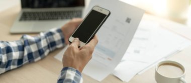 business man use phone to scan barcode or QR codes to pay credit card bill after receiving document invoice online. payment, receive, paying electricity, digital payments without money, technology