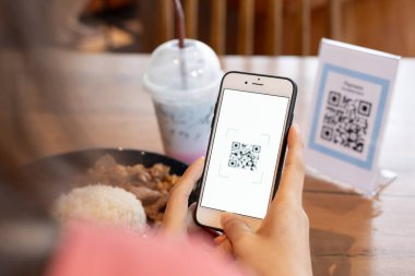 Kadın, kafeterya restoranında sipariş menüsü için dijital dağıtım ile QR kodunu taramak için akıllı telefon kullanıyor. Menüyü ve siparişi seçin ve indirimi toplayın. E cüzdan, teknoloji, online ödeme, kredi kartı, banka uygulaması