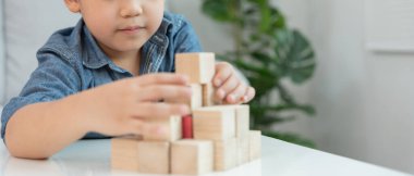 Mutlu Asyalı çocuk oyun oynuyor ve oyuncak bloklarını öğreniyor. Çocuklar evde çok mutlu ve heyecanlı. Çocuk oyun, etkinlik, gelişme ve dikkat eksikliği hiperaktivite bozukluğuyla çok iyi vakit geçiriyor