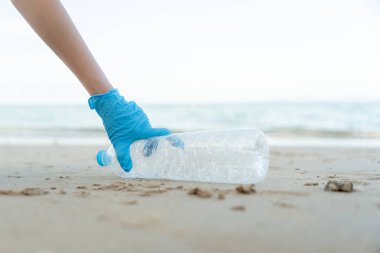 Okyanusu kurtar. Gönüllü olarak plajdaki çöpleri topluyor ve plastik şişeler suda yaşayan canlılara zarar gelmesini engelliyor. Dünya, Çevre, Yeşilci Gezegen, küresel ısınmayı azaltmak, Dünya 'yı kurtarmak