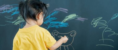 Mutlu Asyalı çocuklar siyah tahtada boya öğreniyor. Etkinlik, gelişim, IQ, EQ, meditasyon, beyin, kas, temel beceriler, ailenin birlikte zaman geçirmesi. Tatil