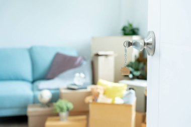 Moving house, relocation. The key was inserted into the door of the new house, inside the room was a cardboard box containing personal belongings and furniture. move in the apartment or condominium