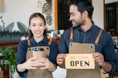 Küçük işletme kafesinin ilk gününde Asya 'lı çift sahibi mutlu. Güvenliği, temizliği ve kafeyi açmayı garanti ediyor. Yeni normal. KOBİ, hoş geldiniz, restoran, ev yapımı, aile 