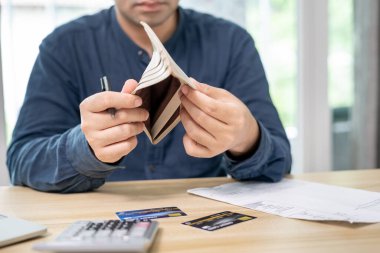 Yüklü faturaları ve faturaları olan stresli ve baş ağrısı çeken Asyalı bir adamın harcamaları ve kredi kartı borçlarını ödeyecek parası yok. kıtlık, mali sorunlar, mortgage, kredi, iflas, iflas, yoksul, boş cüzdan