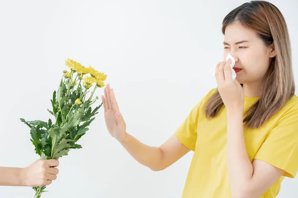 Pollen Allergies, asian young woman sneezing in a handkerchief or blowing in a wipe, allergic to wild spring flowers or blossoms during spring. allergic reaction, respiratory system problem