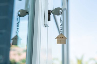 Landlord key for unlocking house is plugged into the door. Second hand house for rent and sale. keychain is blowing in the wind. mortgage for new home, buy, sell, renovate, investment, owner, estate