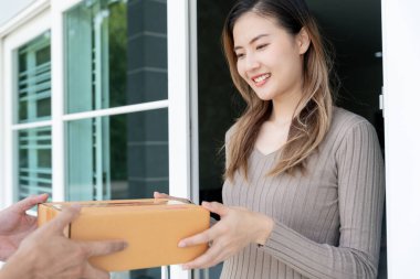Mutlu gülümseyen kadın evdeki kuryeden kutuları alıyor. Teslimatçı ekspres teslimat gönderdi. Online alışveriş, kağıt konteynırlar, paket servisi, postacı, teslimat servisi, paketler.
