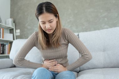 stomach ache. Asian women have abdominal pain, indigestion, gastritis, menstrual cramps, flatulence, diarrhea, distention, colon cancer, belly inflammation problem, suffer food poisoning, abdomen
